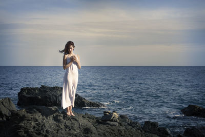 Woman in white dress by the sea