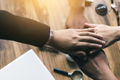 Business colleagues stacking hands at office