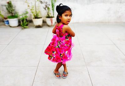 Portrait of cute girl standing on paved street