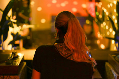 Rear view of woman standing at night