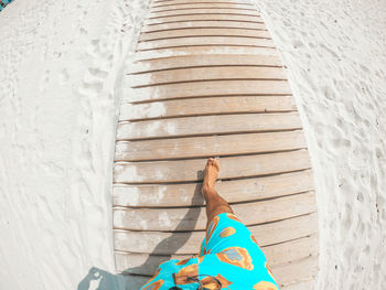 Low section of woman relaxing on wooden floor