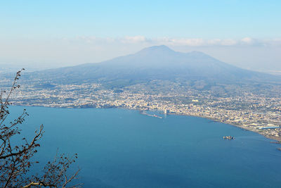 Aerial view of city by sea against sky