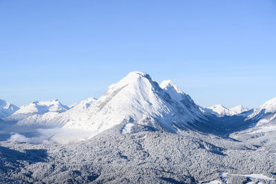 Scenic view of snowcapped mountains against blue sky