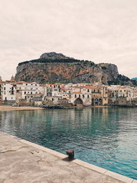 Building by sea against sky in city