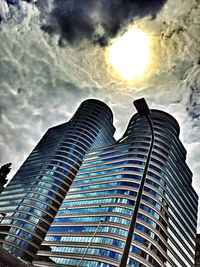 Low angle view of modern building against cloudy sky