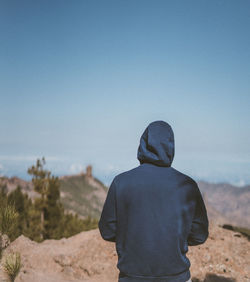 Rear view of man looking at camera