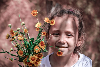 Portrait of cute girl with flowers outdoors