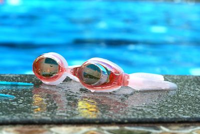 Close-up of swimming goggles on poolside