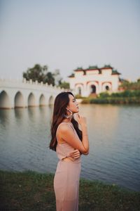 Woman standing against bridge against sky