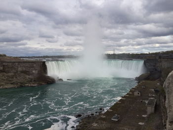 Niagara falls against cloudy sky