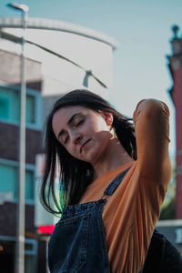 Young woman standing against building