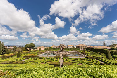 Built structure on landscape against cloudy sky