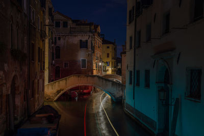 Canal amidst illuminated city at night