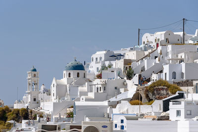 Houses in town against clear blue sky