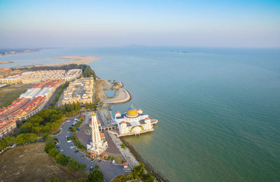 Aerial view of malacca straits mosque by blue sea against sky