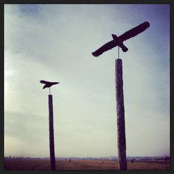 Low angle view of windmill on beach against sky