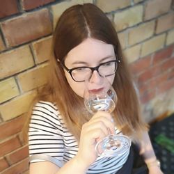 Portrait of young woman drinking glasses