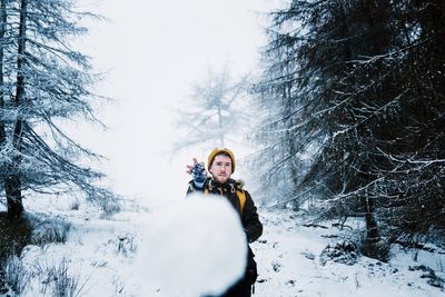 Portrait of young woman standing in snow