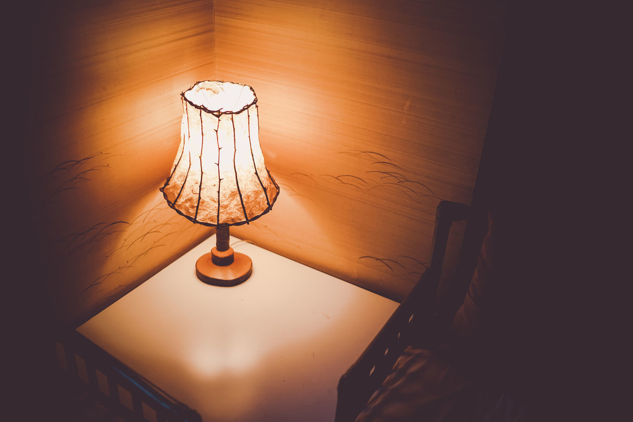 lighting equipment, indoors, electric lamp, illuminated, light, no people, home interior, lamp, domestic room, lighting, electricity, table, glowing, lampshade, wall - building feature, light - natural phenomenon, light fixture, furniture, darkness, electric light, wood, hanging, light bulb