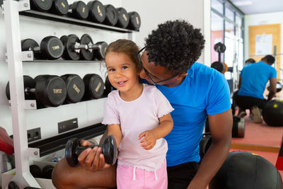 High angle view of man holding dumbbell in gym