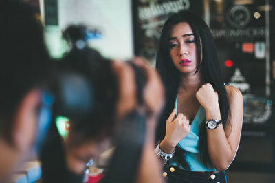 Close-up of photographer with fashion model in background