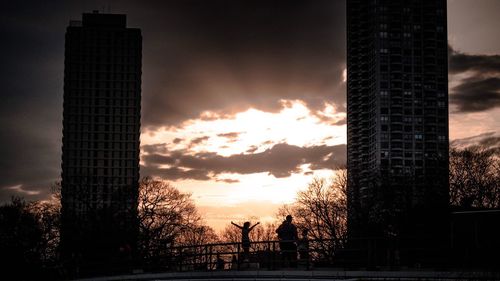 Silhouette of skyscrapers against sunset sky