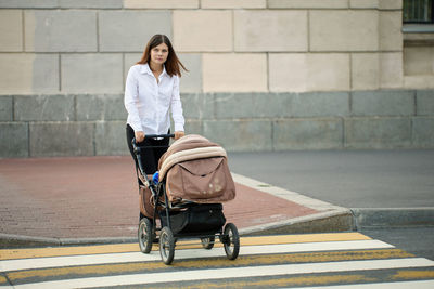 Full length of woman sitting on road in city