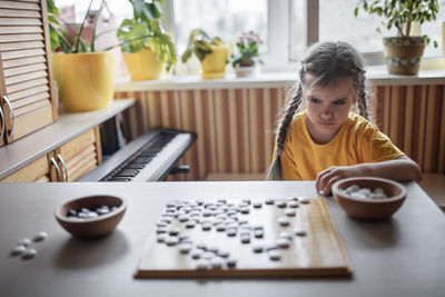 Girl sitting on table at home