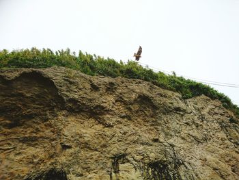 Low angle view of man against mountain against clear sky