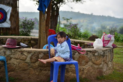 Rear view of girl sitting on plants