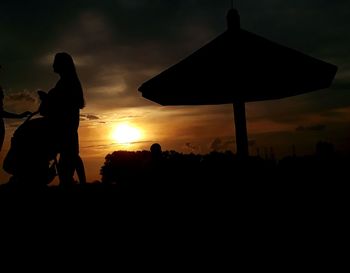 Silhouette people against sky during sunset