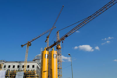 Low angle view of crane against blue sky