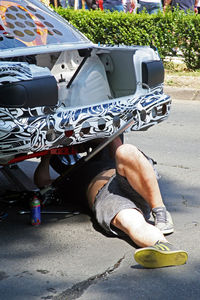 Low section of man sitting on road