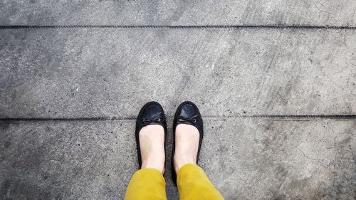 Low section of woman wearing shoes while standing outdoors