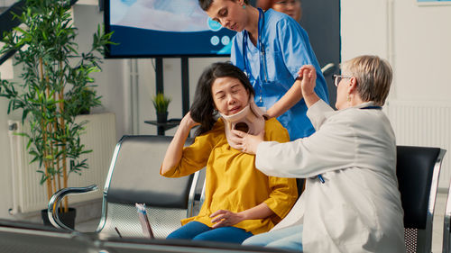 Female doctor examining patient in clinic