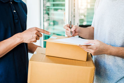 Midsection of man holding woman standing in box