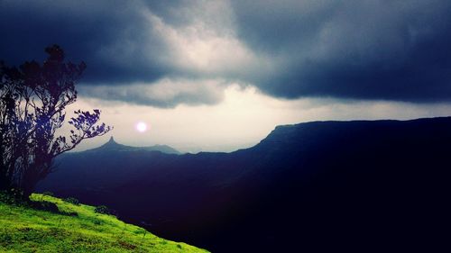 Scenic view of mountains against cloudy sky