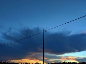 Low angle view of silhouette electricity pylon against sky during sunset