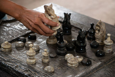 Midsection of person playing guitar on chess board