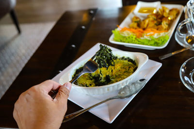 High angle view of person holding food on table