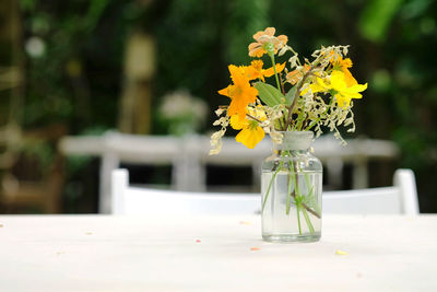 Close-up of yellow flower vase on table