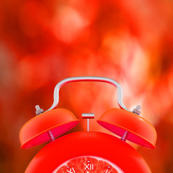 Close-up of alarm clock against red illuminated light