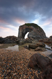 Rock formation on land against sky during sunset