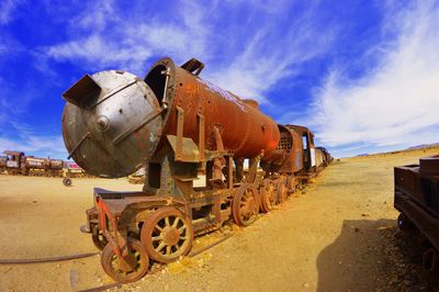 Abandoned train against sky on sunny day