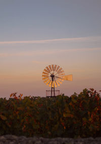 Windmill in a field with a sunset in the background. french countryside. red sunset