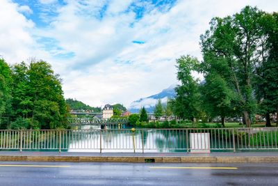 Bridge over river by buildings against sky