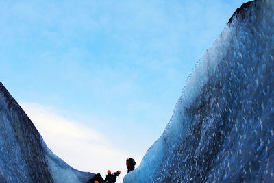 People standing on snow covered mountain against sky