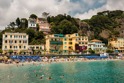 Buildings by sea against sky
