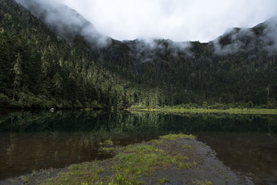 Scenic view of lake by mountains against sky