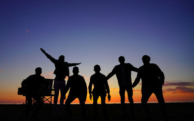 Silhouette people against clear sky during sunset